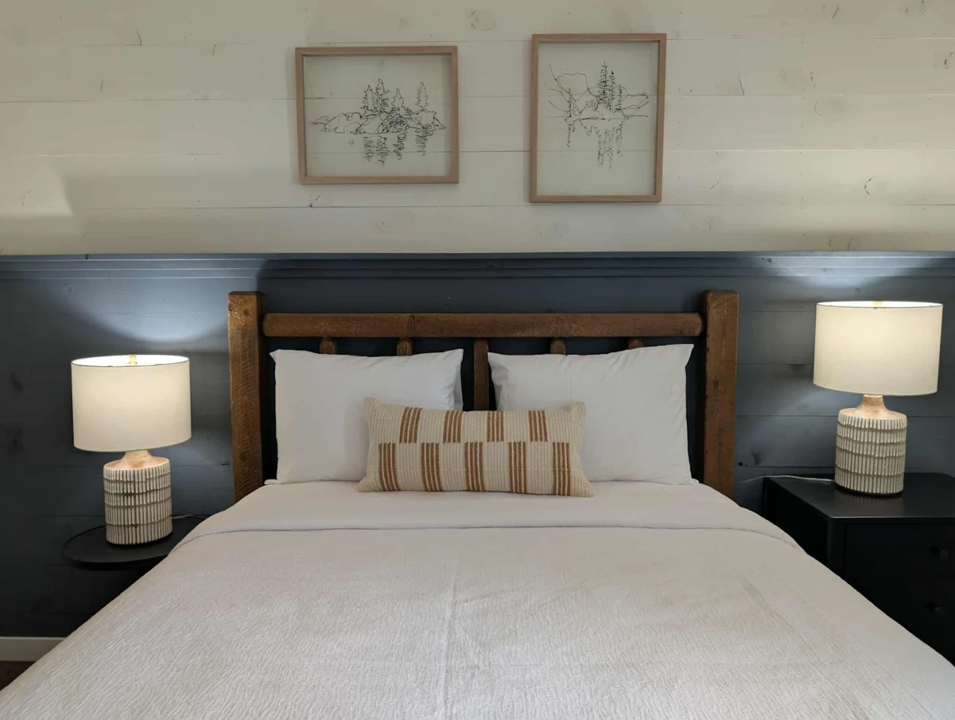 Queen bed with wooden headboard and lamps
