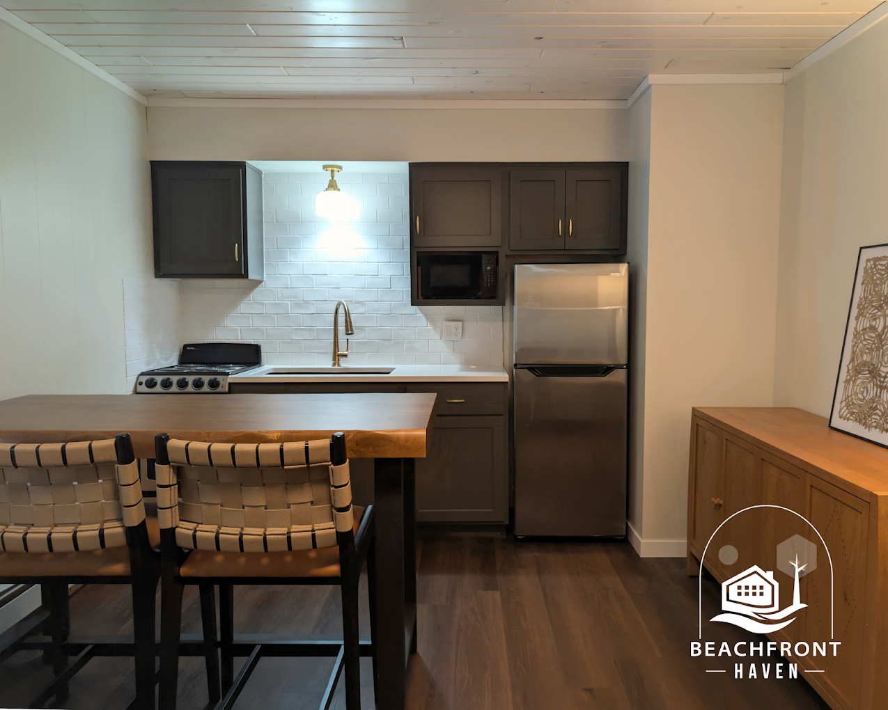 Kitchenette with stainless fridge and wood credenza
