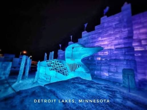 Ice-carved loon lit blue and purple at night at the Detroit Lakes ice palace