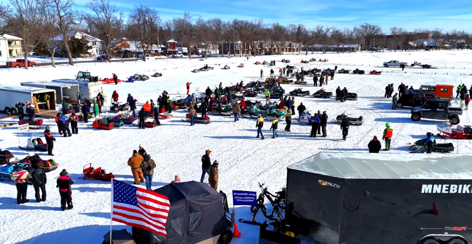 Vintage snowmobile rally gathered on the frozen lake near downtown